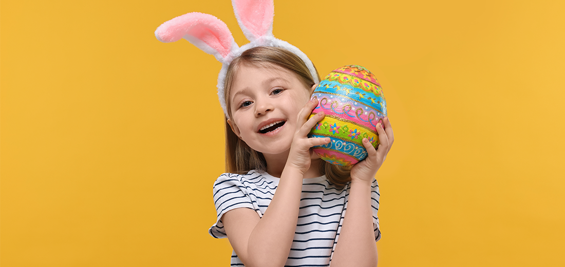 Kind mit Hasenohren hält bemaltes Ei in der Hand, Oster-Kunst-Aktion im QUARREE